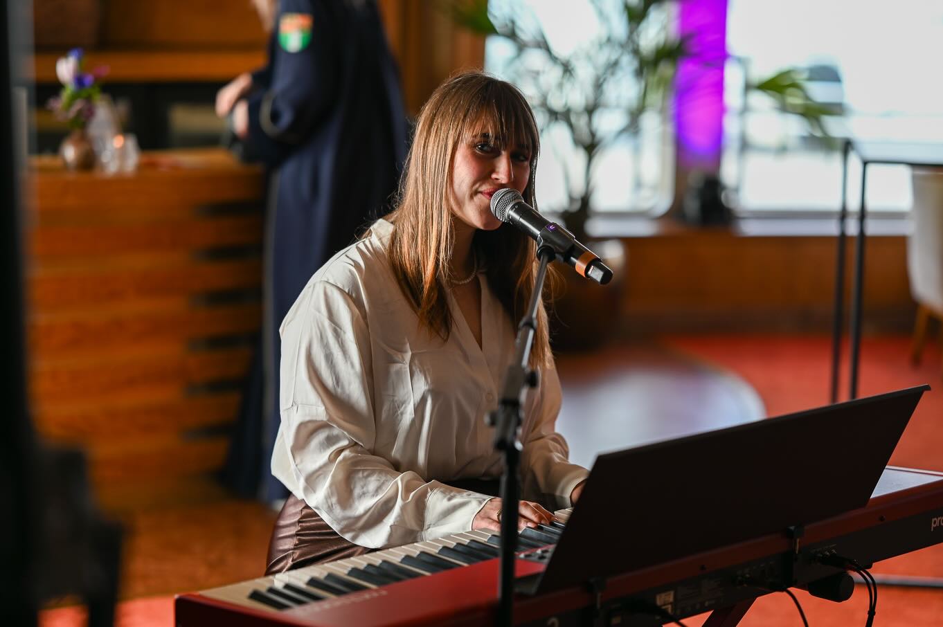 Nina zingt en begeleidt zichzelf op keyboard tijdens een optreden