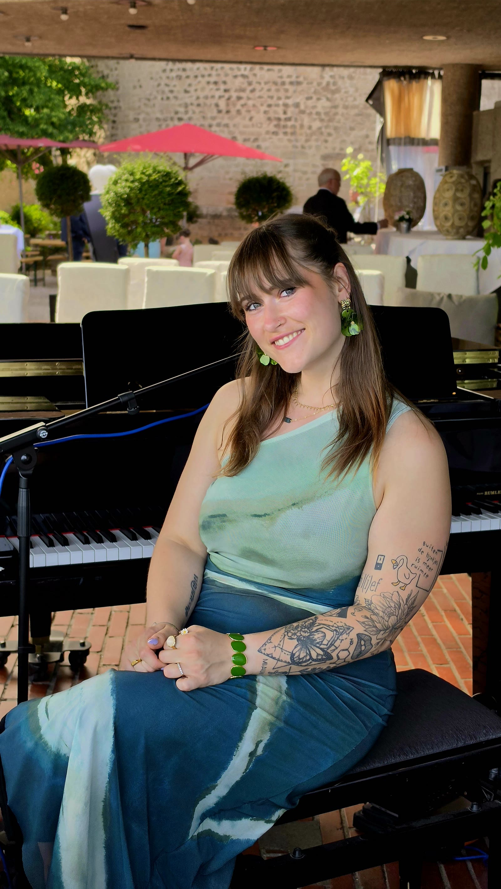 Nina Sophia achter de piano op een terras