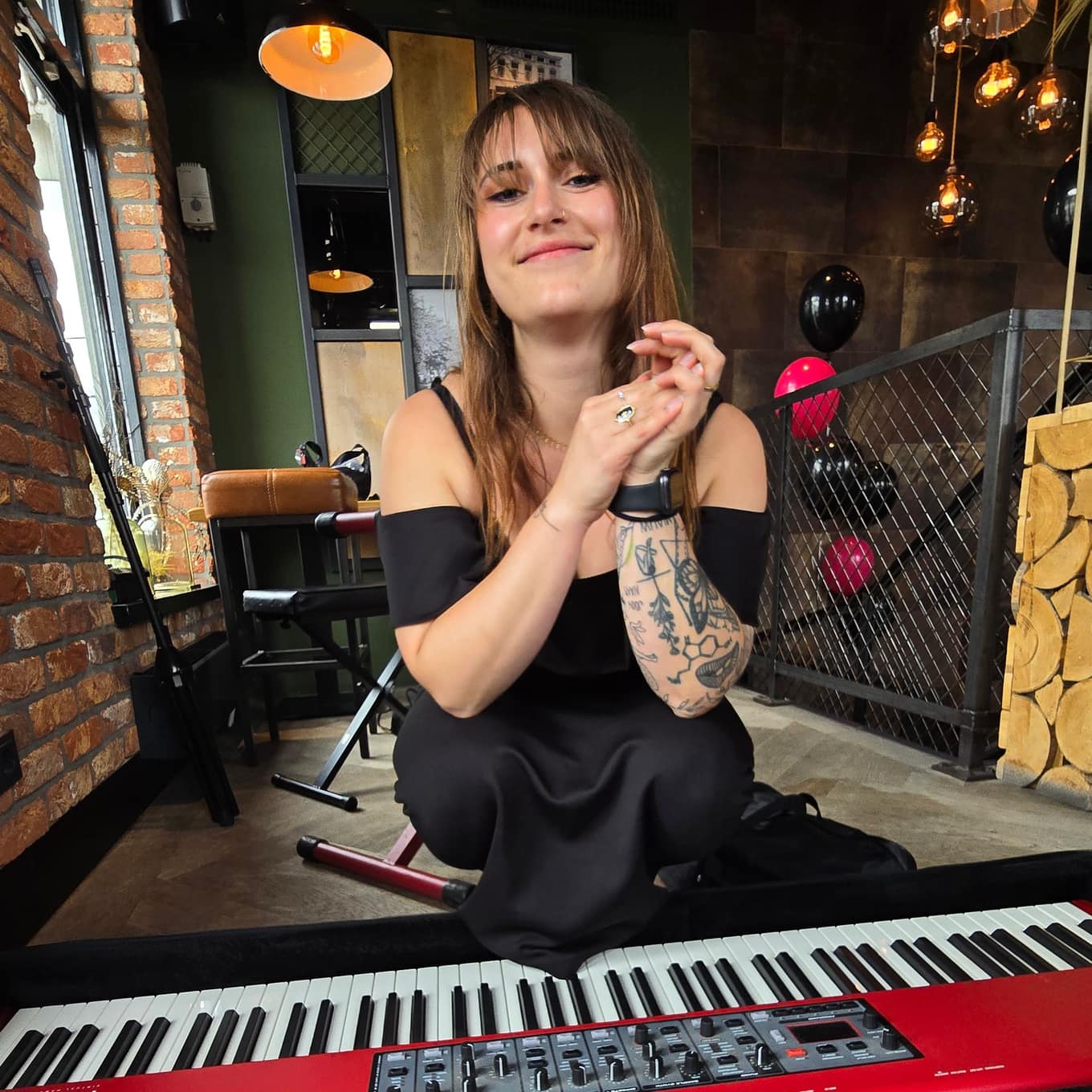 Nina Sophia zit lachend achter haar keyboard tijdens een optreden